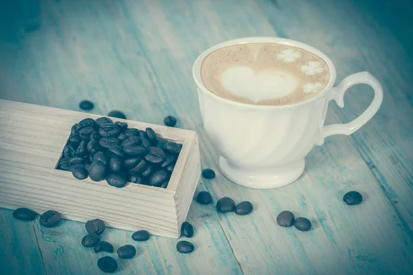Coffee beans on wood table — Stock Photo, Image