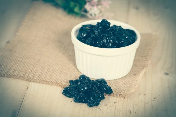 Black raisin or dried grape on wood — Stock Photo, Image