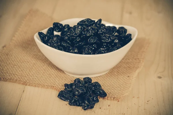 Black raisin or dried grape on wood — Stock Photo, Image