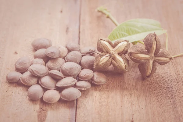 dried capsule seeds fruit of Sacha Inchi peanut on wooden