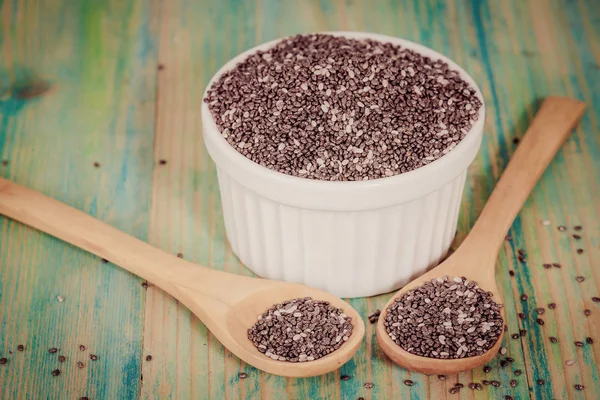 Nutritious chia seeds in bowl and spoon on a wooden — Stock Photo, Image