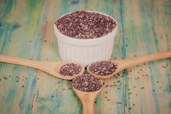 Voedzame chia zaden in een kom en lepel op een houten — Stockfoto