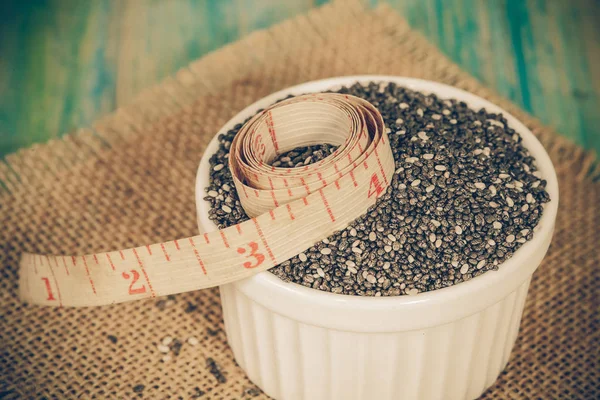 Chia seeds in bowl with measuring tape. — Stock Photo, Image