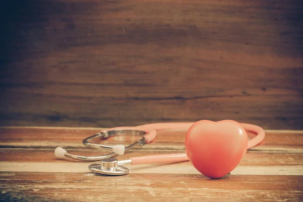 Červené zátiší srdce a stetoskop na dřevo — Stock fotografie