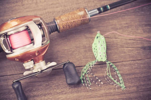 Fishing tackle - Baitcasting Reel, hooks and lures on wooden ba