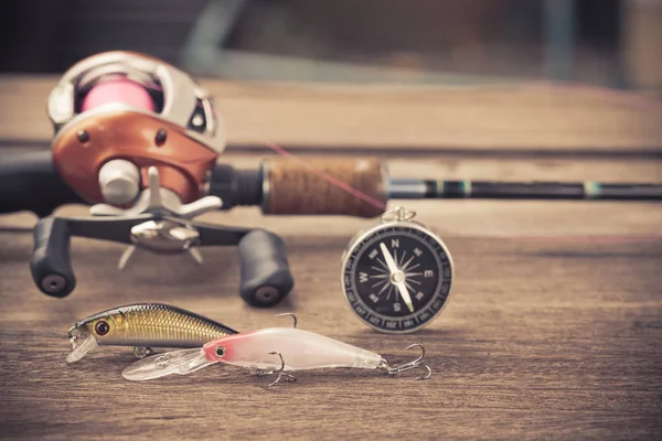 Fishing tackle - Baitcasting Reel, hooks and lures on  wooden ba — Stock Photo, Image