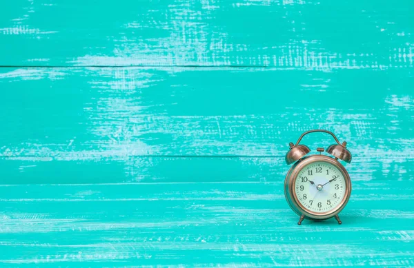 Relógio de alarme velho na cor de fundo de madeira — Fotografia de Stock