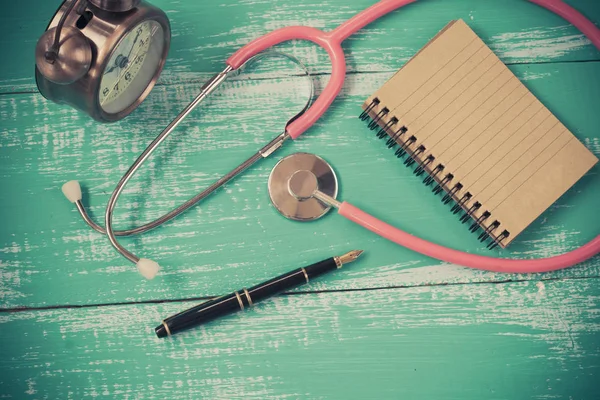 Stéthoscope et livre sur fond de bois vintage — Photo