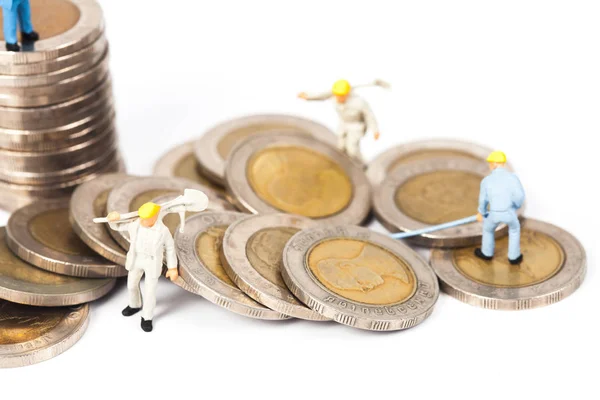 Trabajador en miniatura con pila de monedas —  Fotos de Stock