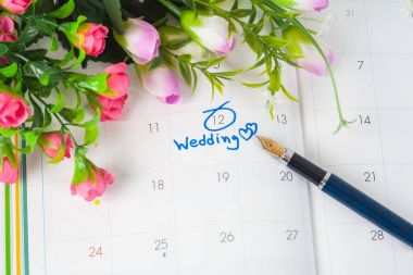 Düğün Not takvimdeki bir hatırlatma çiçek ve kalem ile düğün günü için ayarlar