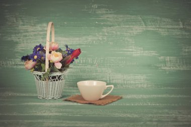 Polis kahve üzerinde tahta arka plan ile sepet içinde çiçek