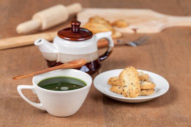 Bir küçük tatlı coo sıcak ve taze yeşil çay ile ev ahşap üzerine yapılan