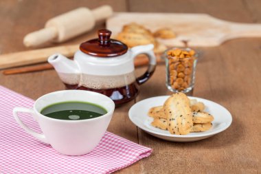 Bir küçük tatlı coo sıcak ve taze yeşil çay ile ev ahşap üzerine yapılan