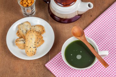 Bir küçük tatlı coo sıcak ve taze yeşil çay ile ev ahşap üzerine yapılan