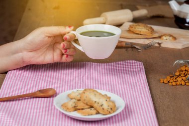 Elini tut sıcak ve taze yeşil çay ile ev ahşap üzerine deli