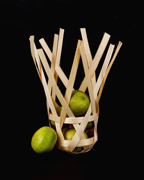 Vápno v bambusovém koši na černém pozadí — Stock fotografie