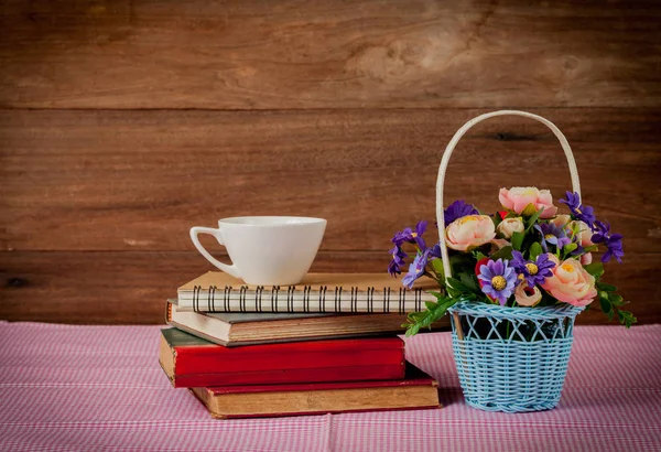 Flower in basket and old book on wood background. — Stock Photo, Image