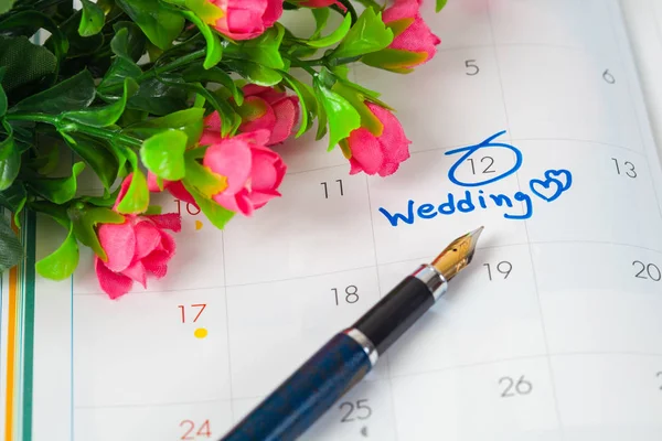 Nota de boda en un calendario establece un recordatorio para el día de la boda con flor —  Fotos de Stock
