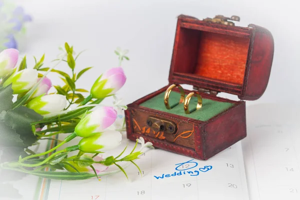 Кольцо дуэта в коробке со свадебной запиской на календаре напомнит о свадьбе — стоковое фото