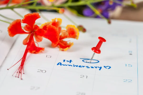 फूल के साथ कैलेंडर पर शब्द वर्षगांठ समारोह योजना पर पिन — स्टॉक फ़ोटो, इमेज