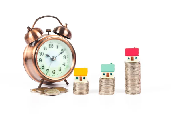 Mini house on coin stack with alarm clock — Stock Photo, Image