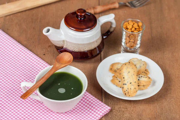 Bir küçük tatlı coo sıcak ve taze yeşil çay ile ev ahşap üzerine yapılan