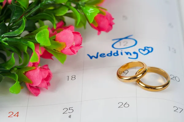 Duo anillo en caja con nota de boda en un calendario establece un recordatorio para la boda —  Fotos de Stock