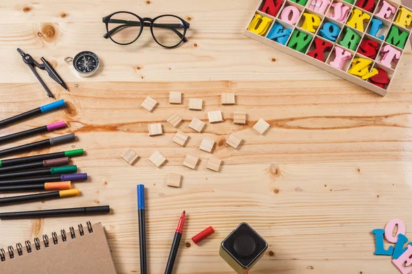 birçok ekipmanları ile ahşap masa üzerinde renk kalem.