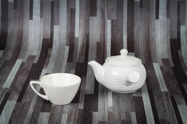 Білий чайний горщик і чашка на дереві — стокове фото