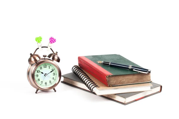 Alarm clock with love heart sign and old book on isolate — Stock Photo, Image