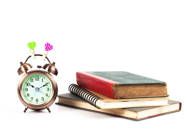 Alarm clock with love heart sign and old book on isolate — Stock Photo, Image