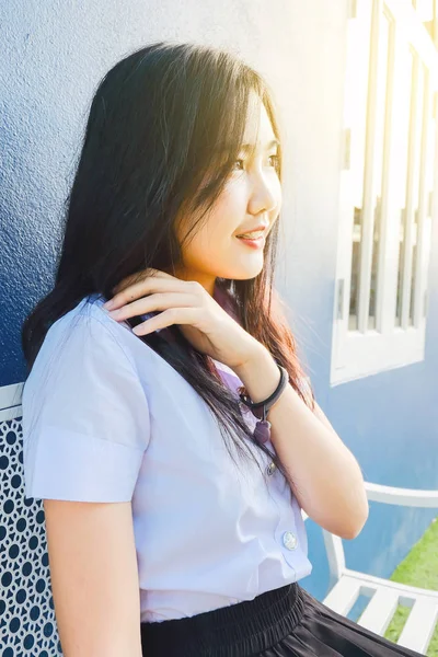 Genç öğrenci kız okulda Tekdüzen oturmak 