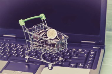 Dizüstü bilgisayar ve çalışma alanı o sikkelerinde küçük alışveriş sepeti içerir