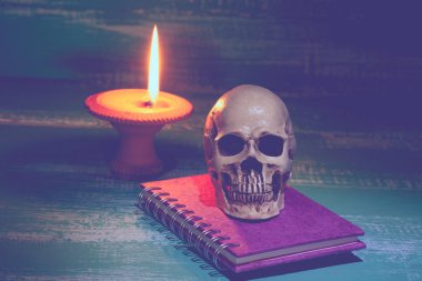 Natürmort insan kafatası ve şamdan ile eski kitap 