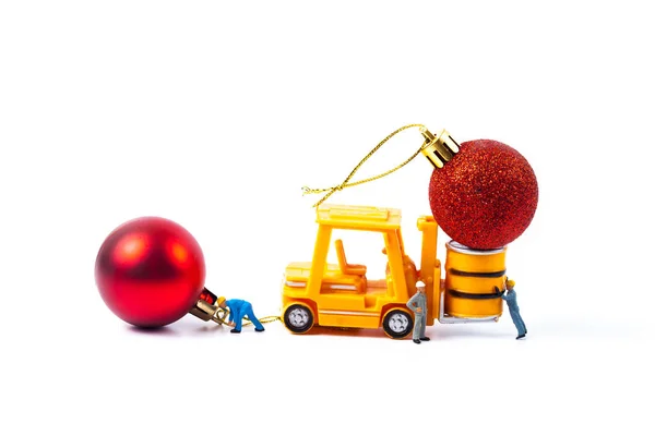 Miniaturarbeiter und kleiner Gabelstapler mit Weihnachtskugel — Stockfoto