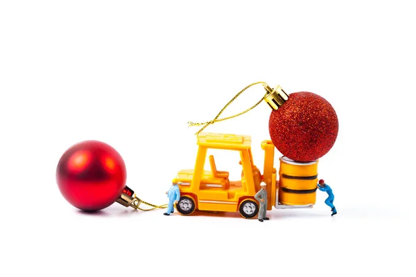 Trabalhador em miniatura e pequena empilhadeira com bola de Natal — Fotografia de Stock