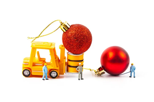 Trabalhador em miniatura e pequena empilhadeira com bola de Natal — Fotografia de Stock