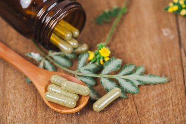 Bitkisel ilaç kapsül bitki sağlıklı beslenme ve iyi yaşam, yumuşak odak rustik ahşap masanın üzerinden.