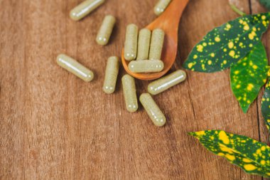 Bitkisel ilaç kapsül bitki sağlıklı beslenme ve iyi yaşam, yumuşak odak rustik ahşap masanın üzerinden.