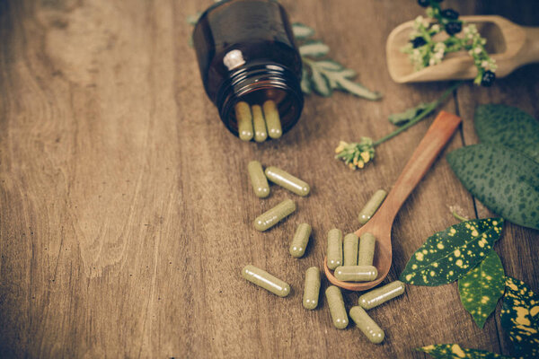 Herbal medicine capsules spilling out of a bottle ,soft focus.