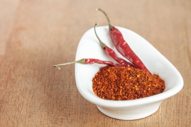 Acı biber beyaz tabak ve ahşap masa üzerinde kurutulmuş biber.
