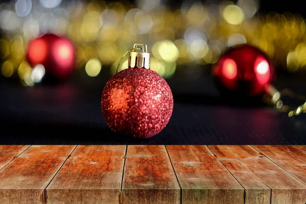 Holzplatte Tisch mit roter Kugel Weihnachtsdekoration auf grüner Kiefer — Stockfoto