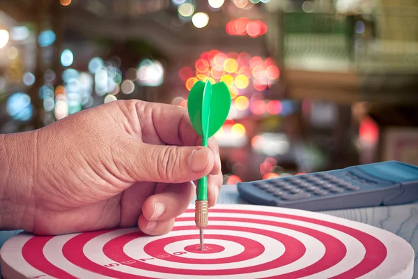 Flecha de dardo en la mano en el tablero de dardos objetivo, concepto de éxito empresarial — Foto de Stock