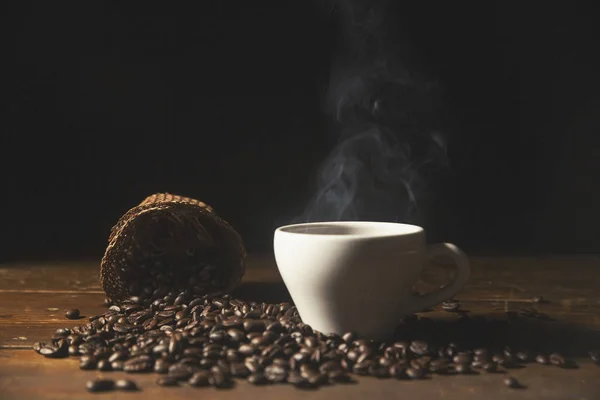 Café noir chaud dans une tasse avec grains de café  . — Photo