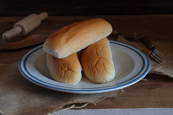 Loafs de pão quente fresco fora do forno na mesa de madeira . — Fotografia de Stock