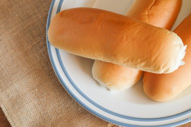 Fırından taze ekmek somunları ahşap masanın üzerinde..