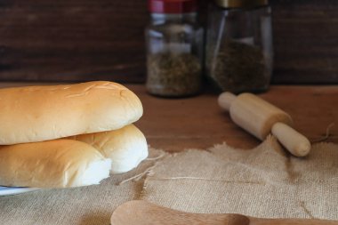 Fırından taze ekmek somunları ahşap masanın üzerinde..