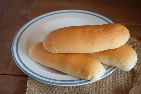 Loafs of fresh hot bread out of the oven on wood table. — Stock Photo, Image