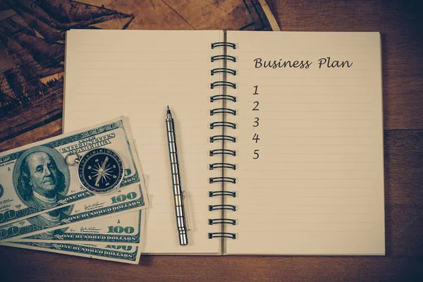 Plano de negócios em nota de livro com bússola vintage e caneta-tinteiro — Fotografia de Stock