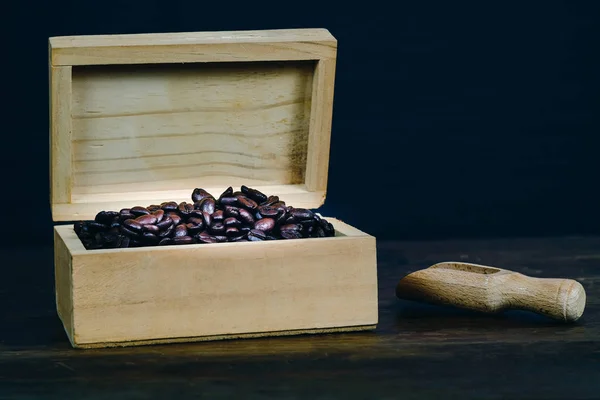 Coffee bean in wood box on old wood background.